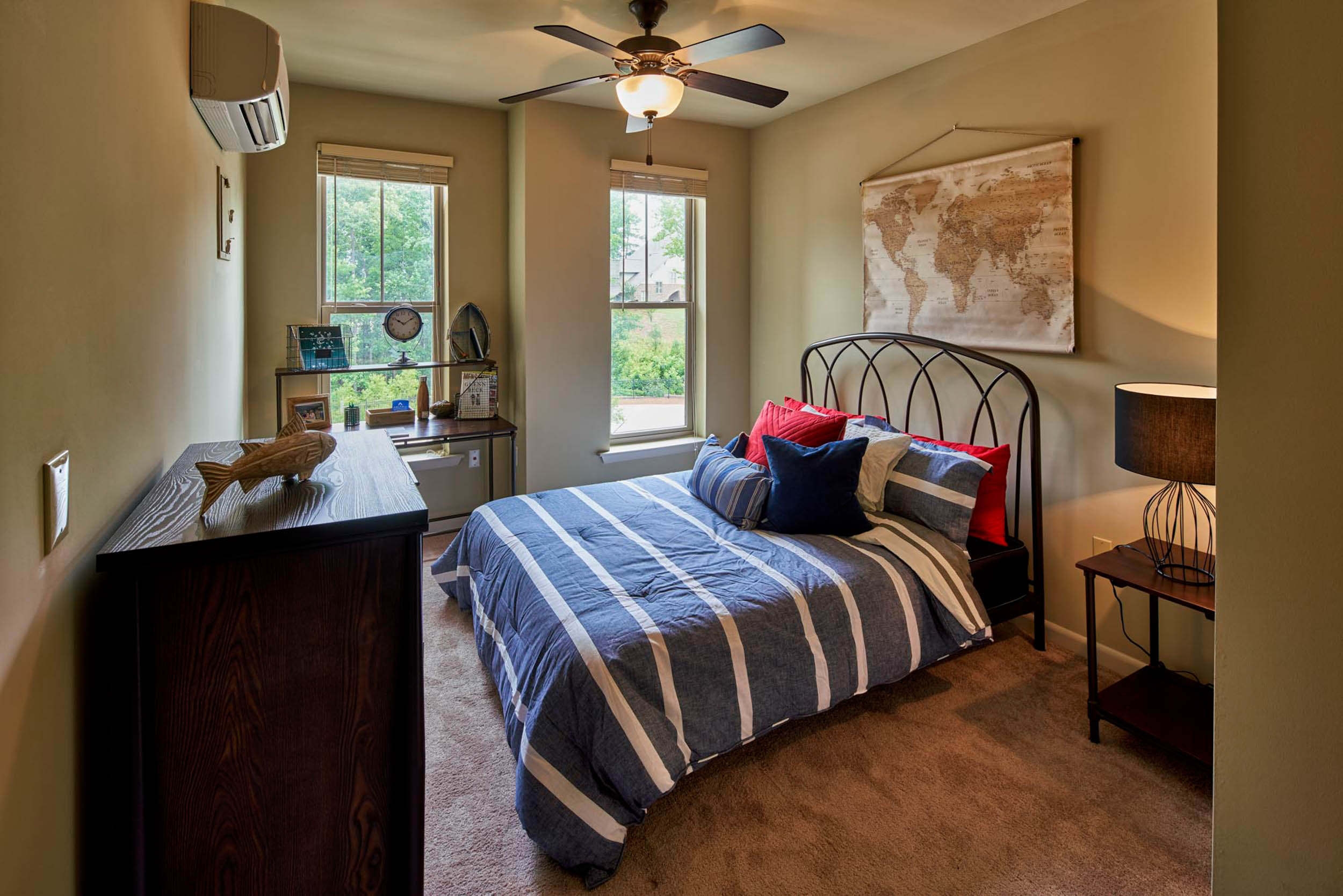 Bedromm with beige walls and red white and blue bedding