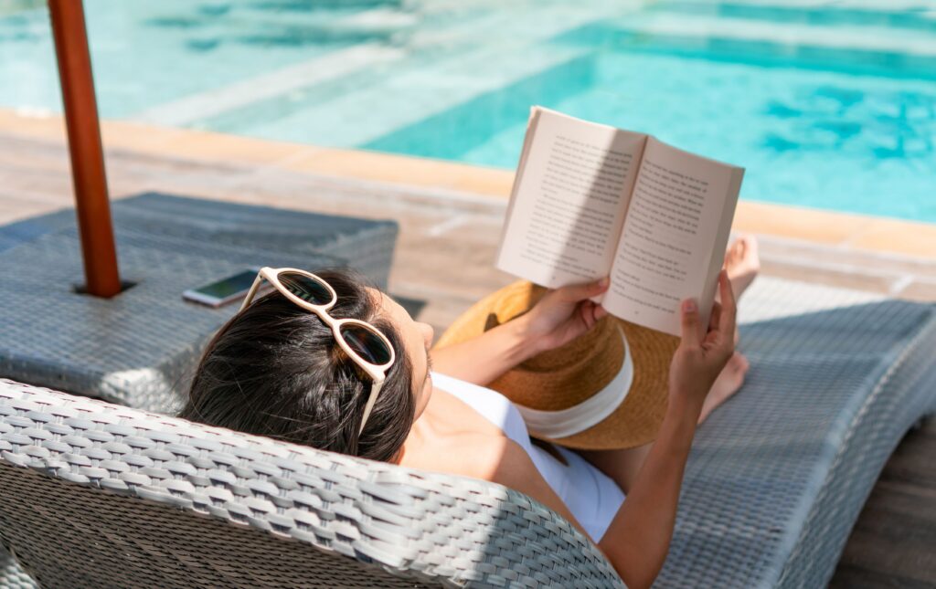Students studying by the resort-style pool at Arcadia Student Living, an off-campus student apartment complex near UNCC.